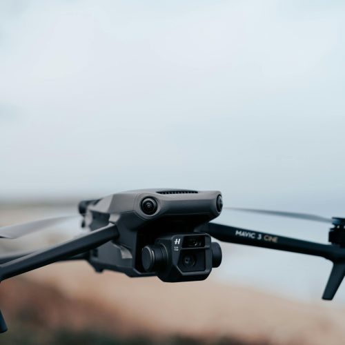 Close-up view of a drone flying against a serene blue sky, showcasing modern technology.